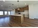 Bright kitchen with wood cabinets, stainless appliances, expansive island with white countertops, and pendant lighting at 804 Hillfarm Dr, Wake Forest, NC 27587