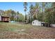 Large fenced backyard with chicken coops, a greenhouse, storage shed and mature trees at 928 Magnolia Ridge Way, Fuquay Varina, NC 27526