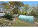 Backyard with a fish pond and greenhouse surrounded by mature trees at 928 Magnolia Ridge Way, Fuquay Varina, NC 27526