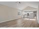 Open-concept living room with wood floors, vaulted ceiling and open to modern white kitchen at 0 Jasmine Rd, Fuquay Varina, NC 27526