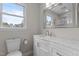 Bright bathroom featuring a vanity with a marble countertop and a decorative framed mirror at 100 Royall Rd, Oxford, NC 27565