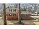Traditional two-story brick home featuring a cozy covered front porch at 100 Royall Rd, Oxford, NC 27565