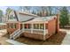 Charming two-story brick and vinyl home with a covered front porch and white railing, nestled among mature trees at 100 Royall Rd, Oxford, NC 27565
