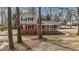 View of charming two-story brick and vinyl home with covered front porch with mature trees in yard at 100 Royall Rd, Oxford, NC 27565