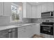 Modern kitchen with white cabinetry, stainless steel appliances, and a bright window at 100 Royall Rd, Oxford, NC 27565