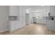 Spacious, updated kitchen featuring stainless appliances, white cabinets, and wood-look flooring at 100 Royall Rd, Oxford, NC 27565