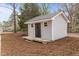Backyard outbuilding with a porch and black door, nestled in a landscaped yard at 100 Royall Rd, Oxford, NC 27565