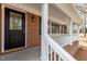 Front porch with brick columns, white railing, and a front door with decorative glass at 100 Royall Rd, Oxford, NC 27565