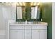 This modern bathroom features granite countertops, new cabinets, and dual mirrors at 10210 Sablewood Drive # 112, Raleigh, NC 27617