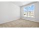Bright, carpeted bedroom featuring natural light from a large window with neutral paint at 10210 Sablewood Drive # 112, Raleigh, NC 27617