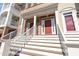 Two-story townhouse units with red doors, white pillars, and ascending stairs leading to the entrance at 10210 Sablewood Drive # 112, Raleigh, NC 27617