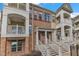 Brick townhouse with multiple stories and balconies featuring white railings and a front entrance with steps at 10210 Sablewood Drive # 112, Raleigh, NC 27617