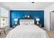 This primary bedroom features a beautiful blue accent wall with a small shelf at 10210 Sablewood Drive # 112, Raleigh, NC 27617