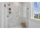 Elegant bathroom features marble tile shower with glass enclosure, a wood bench, and window at 1028 Zelkova Ln, Chapel Hill, NC 27517