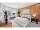 Serene bedroom with wood paneled wall, a large bed, bench seat, and ample natural light from large windows at 1028 Zelkova Ln, Chapel Hill, NC 27517