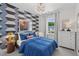 Cozy bedroom showcasing an accent wall, a plush blue comforter, and a modern chandelier at 1028 Zelkova Ln, Chapel Hill, NC 27517