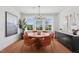 Modern dining room boasts a round table set, hardwood floors, and plenty of natural light from a large window at 1028 Zelkova Ln, Chapel Hill, NC 27517