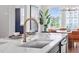 Bright kitchen featuring a large island with a modern faucet, seating, and views of the dining area at 1028 Zelkova Ln, Chapel Hill, NC 27517