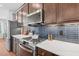 Modern kitchen with stainless steel appliances, dark cabinetry, and white countertops at 1028 Zelkova Ln, Chapel Hill, NC 27517