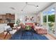 Comfortable living room with a pink sofa, blue accents, and open flow to the modern kitchen at 1028 Zelkova Ln, Chapel Hill, NC 27517