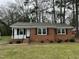 Beautiful red brick home featuring black shutters and a welcoming front porch at 103 Beam Cir, Louisburg, NC 27549