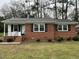 Charming brick home featuring black shutters, and manicured landscaping at 103 Beam Cir, Louisburg, NC 27549