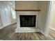Stylish whitewashed brick fireplace with a wooden mantel at 103 Beam Cir, Louisburg, NC 27549