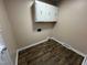 Efficient laundry area with overhead cabinets and wood-look vinyl flooring at 103 Beam Cir, Louisburg, NC 27549