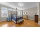 Inviting bedroom featuring a four poster bed, natural lighting, and hardwood flooring at 10540 Byrum Woods Dr, Raleigh, NC 27613
