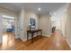 Hallway with hardwood floors, decorative table, and wall art at 10540 Byrum Woods Dr, Raleigh, NC 27613