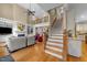 Bright, open living room with hardwood floors, fireplace, built-in shelving, and staircase at 10540 Byrum Woods Dr, Raleigh, NC 27613