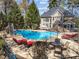 Inviting backyard pool area with lounge chairs, umbrella, and lush greenery at 10540 Byrum Woods Dr, Raleigh, NC 27613