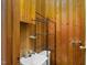 Small wood-paneled bathroom featuring a sink, toilet and metal shelving unit at 1101 Nashville Rd, Rocky Mount, NC 27803