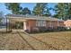 Classic red brick home featuring an attached carport and mature trees in a tranquil neighborhood setting at 1101 Nashville Rd, Rocky Mount, NC 27803
