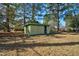 Backyard storage shed, surrounded by trees at 1101 Nashville Rd, Rocky Mount, NC 27803