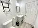 Small bathroom with modern gray vanity, toilet, gray flooring, and white door at 112 Wichita Way, Louisburg, NC 27549