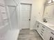 Bright white bathroom featuring a shower and a vanity with double sinks and dark fixtures at 112 Wichita Way, Louisburg, NC 27549