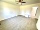 Neutral carpeted bedroom with white walls, ceiling fan and an entry door at 112 Wichita Way, Louisburg, NC 27549