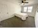 White bedroom featuring neutral carpet, two windows, white door, and fan at 112 Wichita Way, Louisburg, NC 27549