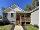 Charming single Gathering home featuring a covered porch, a red door, and gray siding at 112 Wichita Way, Louisburg, NC 27549