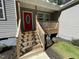 The front entrance features a covered porch, newly painted steps, and a bright red door at 112 Wichita Way, Louisburg, NC 27549