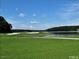 Scenic view of a lush green golf course bordering a tranquil lake with a clear blue sky above at 112 Wichita Way, Louisburg, NC 27549
