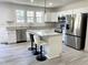 A modern kitchen features white cabinetry, granite countertops, and stainless appliances at 112 Wichita Way, Louisburg, NC 27549