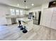 A modern kitchen features white cabinetry, granite countertops, and a stainless steel refrigerator at 112 Wichita Way, Louisburg, NC 27549