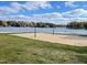 Scenic lake view with a sandy beach volleyball net under a bright blue sky at 112 Wichita Way, Louisburg, NC 27549