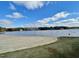 Scenic lake view with a sandy beach and calm water under a bright blue sky at 112 Wichita Way, Louisburg, NC 27549