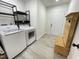 The laundry room offers a modern washer and dryer, gray flooring and a custom-made storage bench at 112 Wichita Way, Louisburg, NC 27549