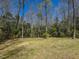 Spacious backyard features green grass and mature trees at 114 Twin Springs Ln, Angier, NC 27501