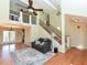 Open-concept living area with hardwood floors, vaulted ceilings, a fireplace, and stairs to the second floor at 114 Twin Springs Ln, Angier, NC 27501