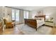 Cozy bedroom with a wood sleigh bed, sitting chair, and hardwood floors at 1301 Flying Hawk Rd, Apex, NC 27523